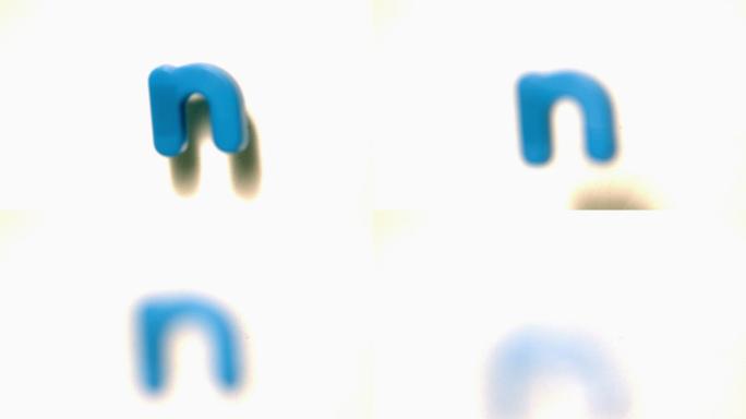 在慢镜头中，蓝色字母n从白色背景上移开