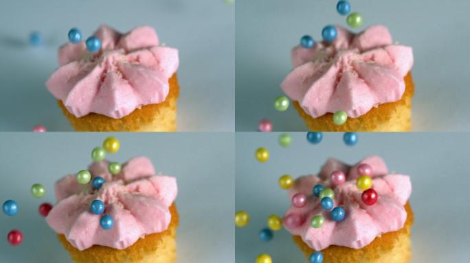 慢镜头里，糖球落在带粉色糖霜的纸杯蛋糕上