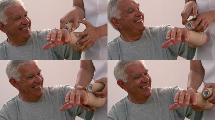 理疗师用慢动作包扎老人的手臂