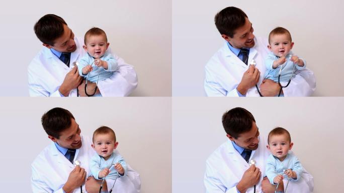 英俊的儿科医生抱着一个男婴在医院的办公室里