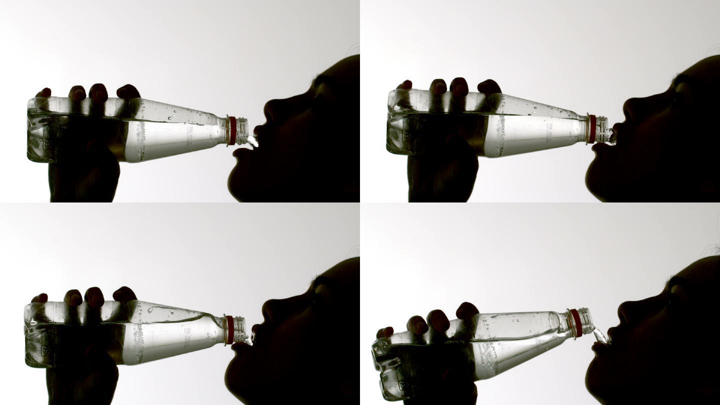 从瓶子里喝水的女人的慢镜头剪影