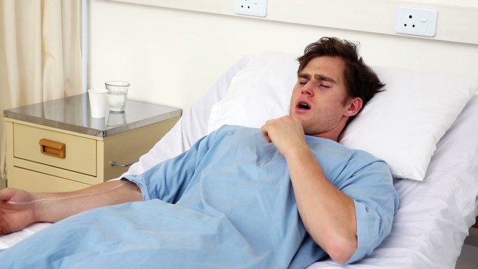 病房里有个病人躺在病床上咳嗽