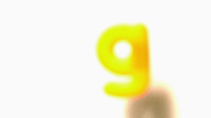 慢镜头中，黄色字母g从白色背景上移开