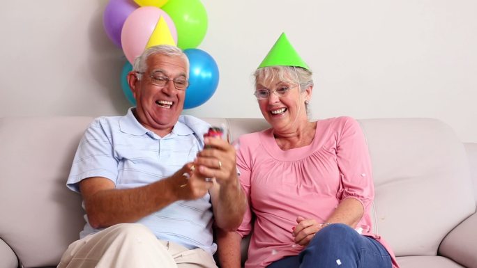 一对老年夫妇在客厅的沙发上庆祝生日