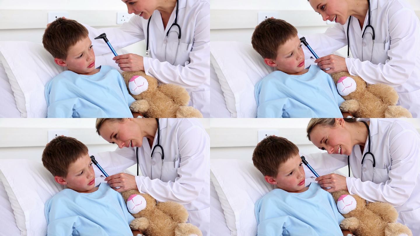 在医院病房的病床上，医生正在检查一个生病的小男孩的耳朵