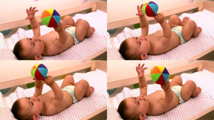 婴儿抱着玩具躺在婴儿床里的慢镜头