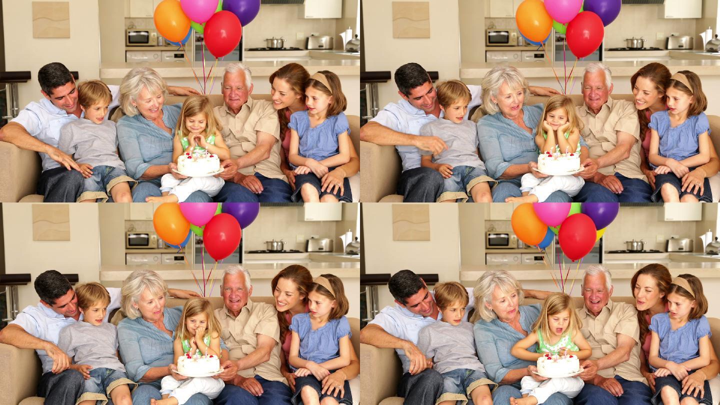 一大家族在客厅的沙发上庆祝小女孩的生日
