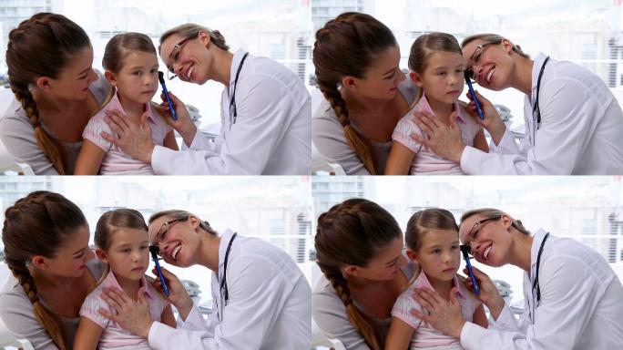 医生在医院的办公室里检查小女孩的耳朵