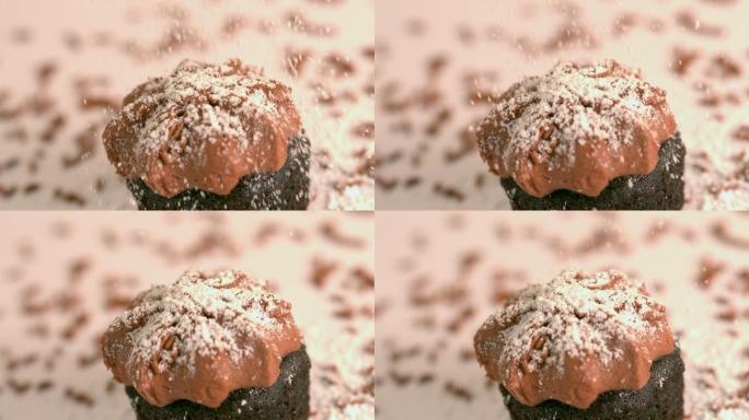 慢镜头中，在巧克力磨砂纸杯蛋糕上筛选糖霜