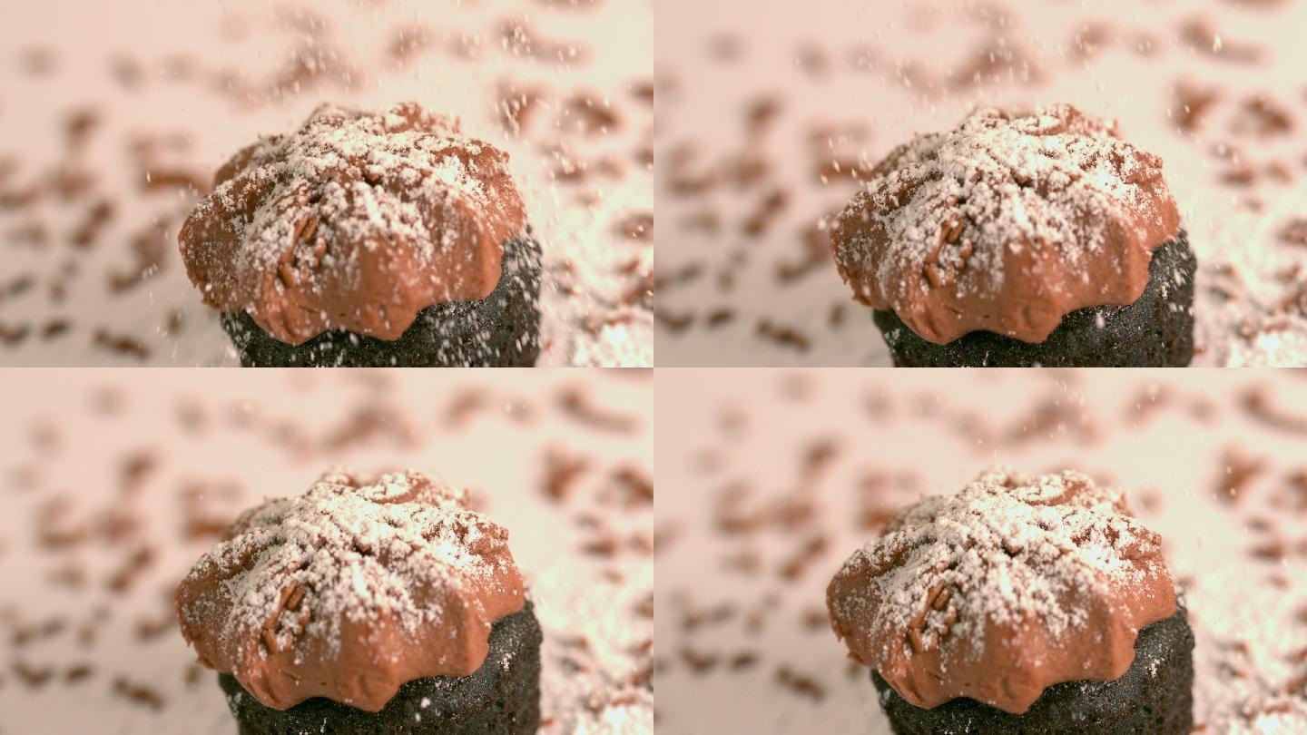 慢镜头中，在巧克力磨砂纸杯蛋糕上筛选糖霜