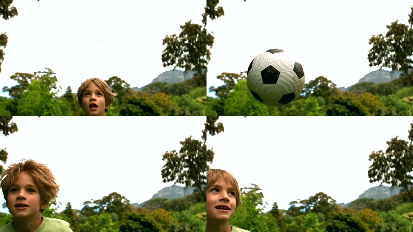 小男孩在公园里踢足球，慢镜头