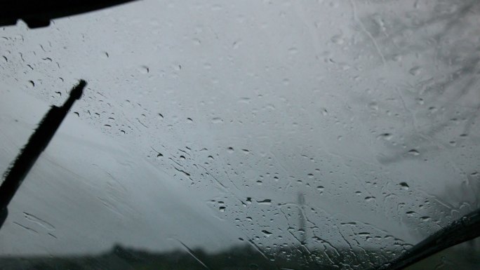 挡风玻璃刮水器以慢动作擦去车窗上的雨水