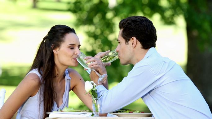 一对情侣在一个阳光明媚的日子里一起在外面吃一顿浪漫的晚餐