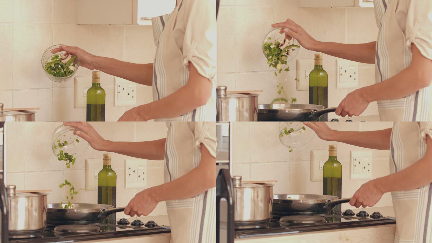 一个女人在厨房里做晚餐的慢镜头