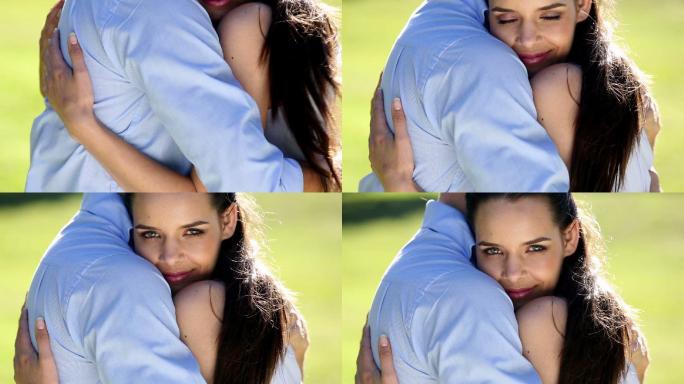 一对幸福的情侣在一个阳光明媚的日子里拥抱在公园里