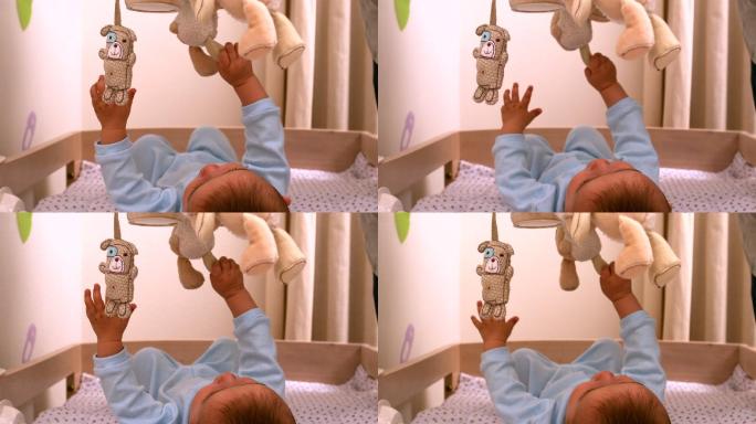 婴儿在他的婴儿床上用慢镜头玩手机