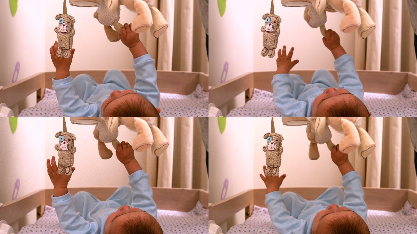 婴儿在他的婴儿床上用慢镜头玩手机