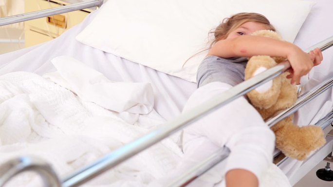 小女孩躺在医院病房的病床上