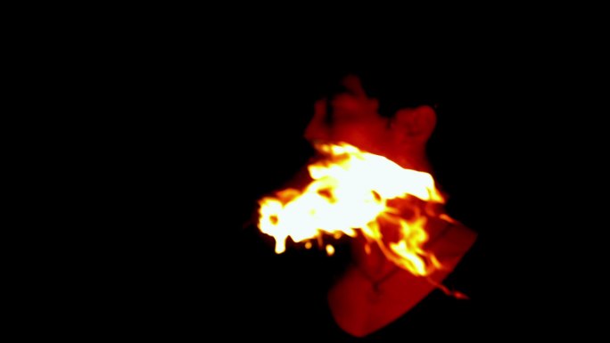 火焰舞者在黑暗中用慢动作将火焰从他的脸上掠过