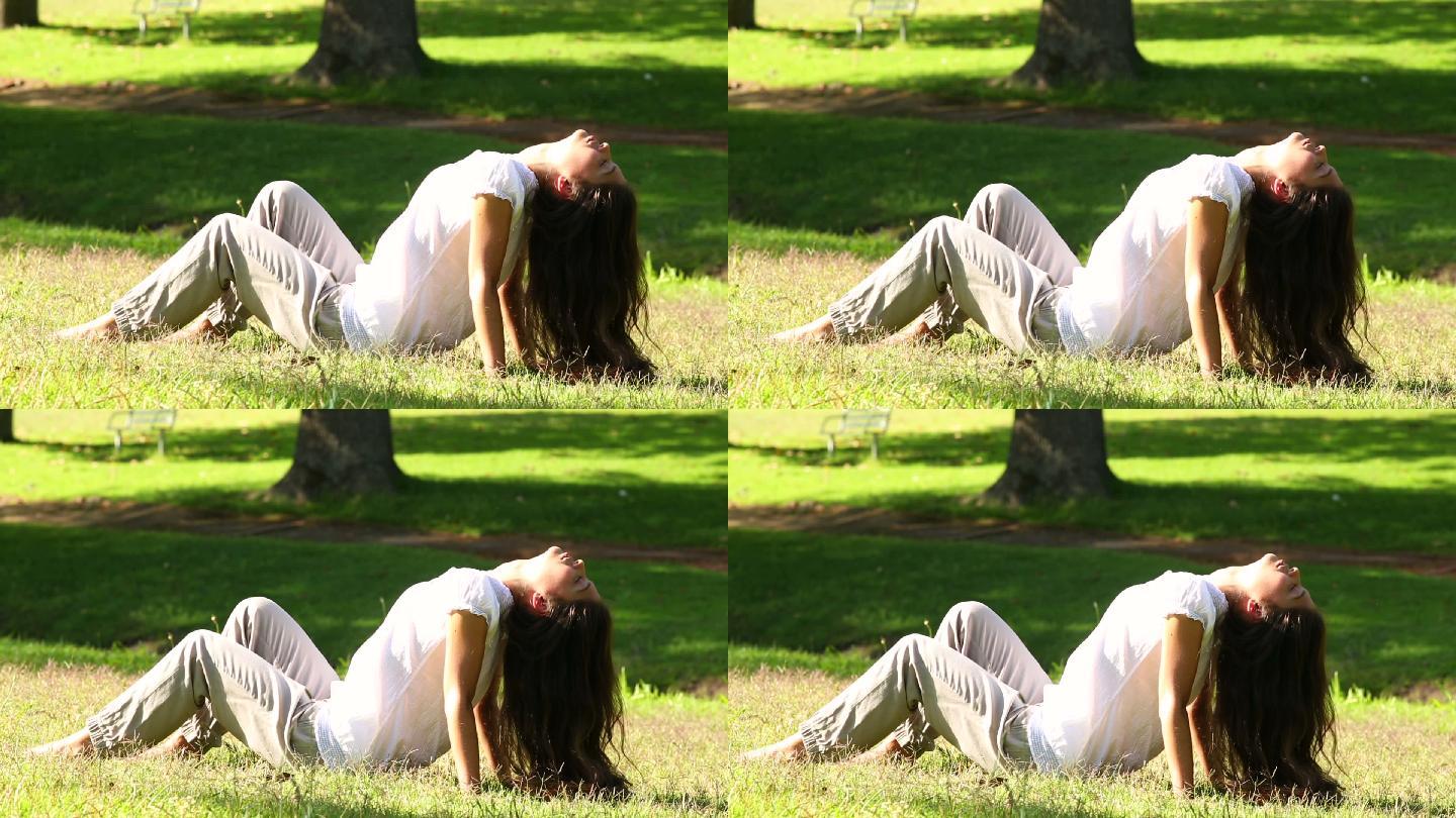 在一个阳光明媚的日子里，一个漂亮的女孩坐在草地上享受阳光