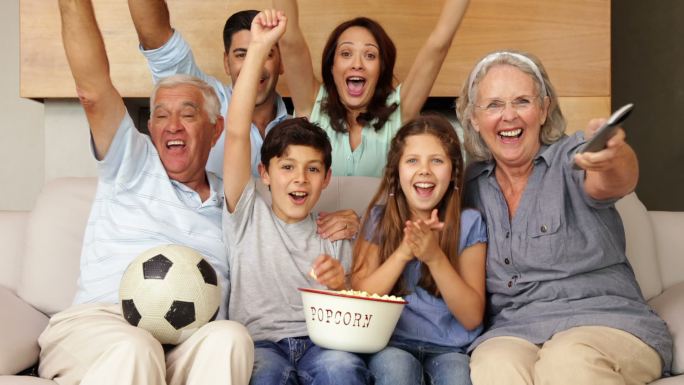 快乐的大家庭在客厅看足球电视