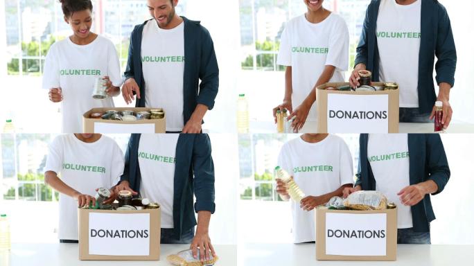 快乐的志愿者团队在整理食物捐赠箱，对着镜头微笑