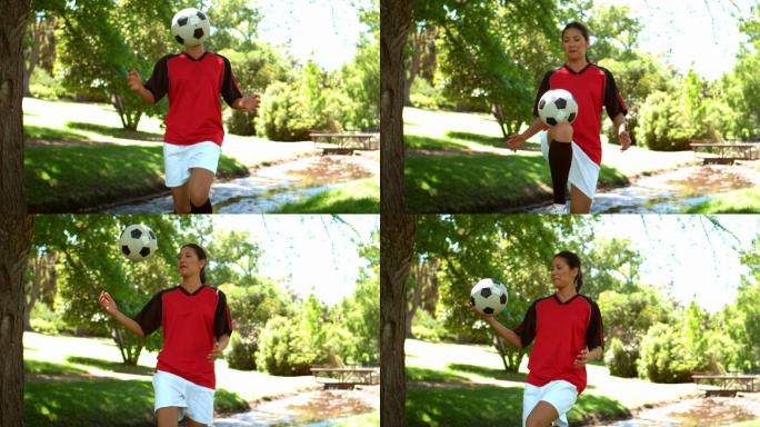 女孩在公园里踢足球的慢镜头