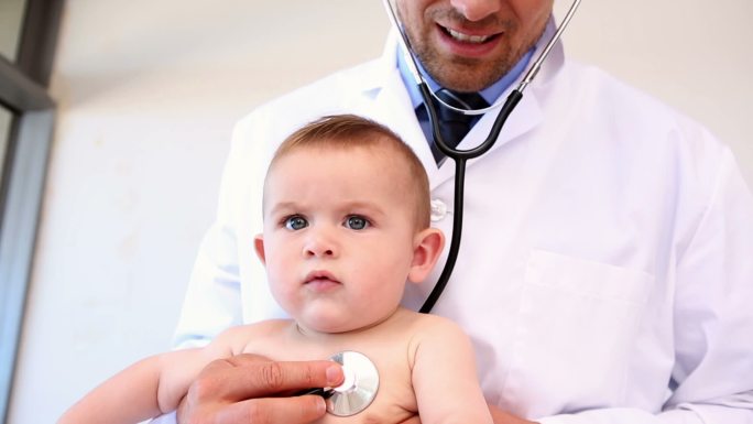 儿科医生在医院的办公室里检查男婴