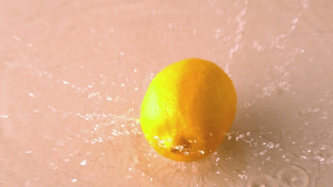 在慢镜头中，柠檬在潮湿的白色表面上落下并旋转