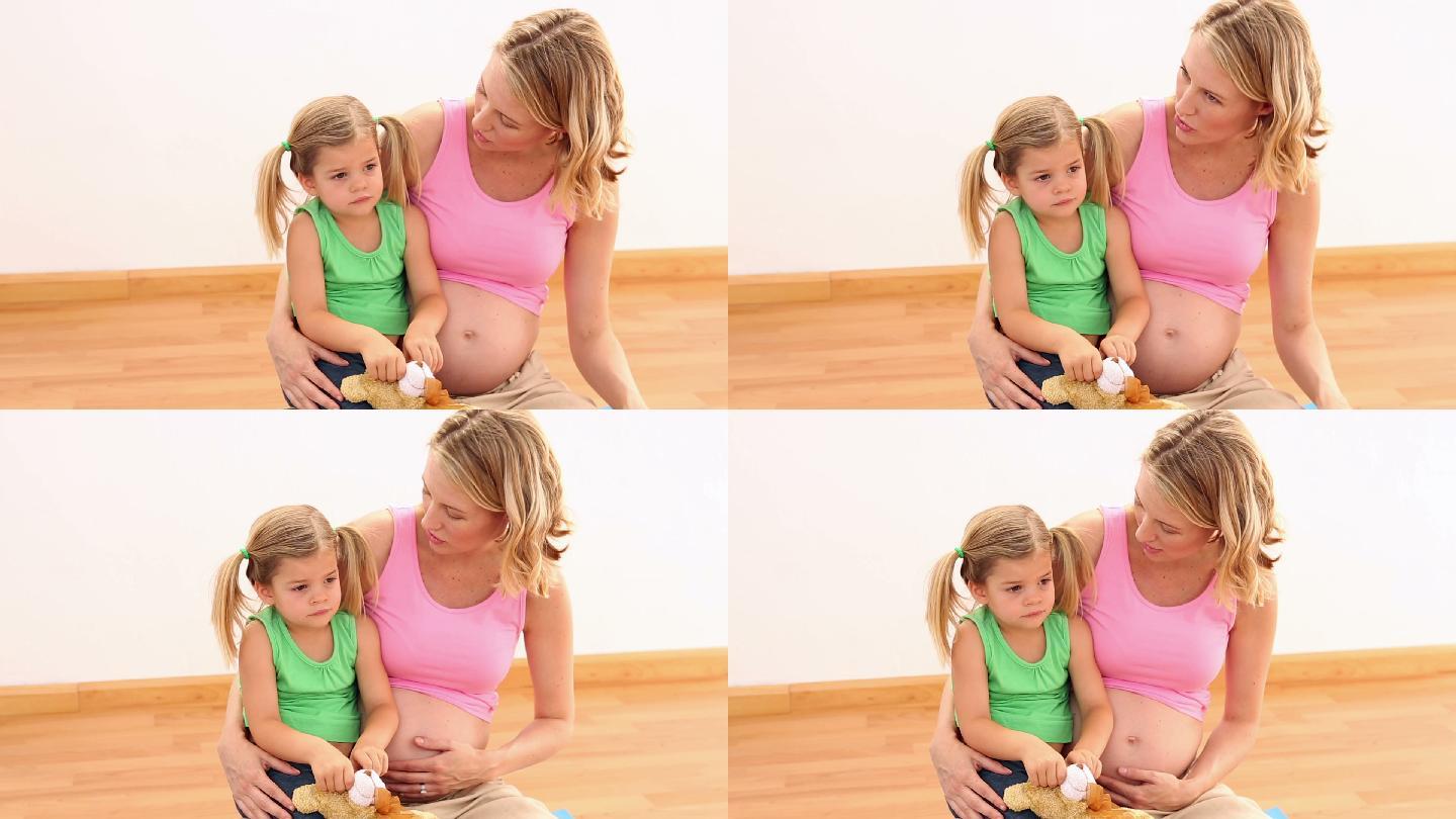 金发孕妇和她的小女儿坐在健身房里