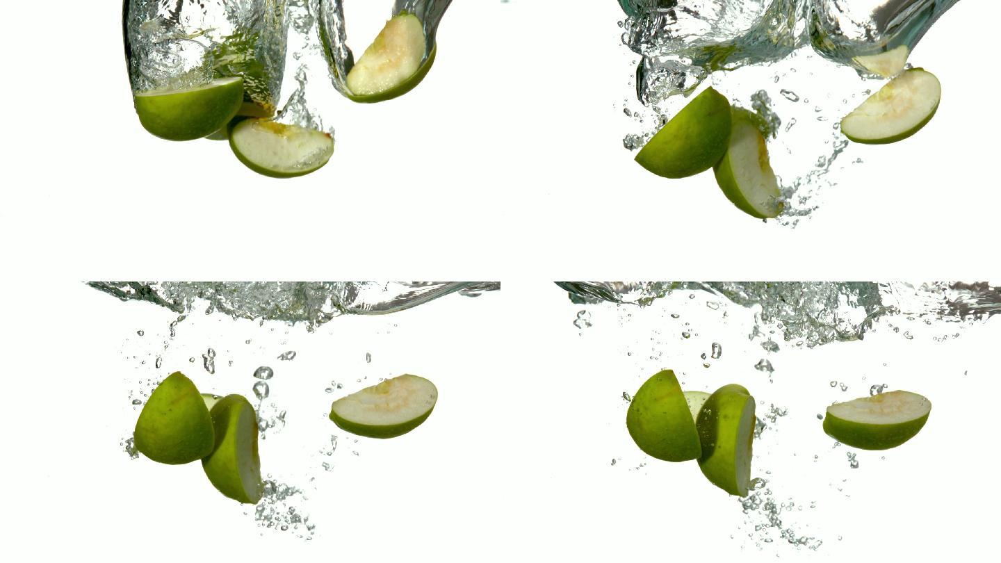 在慢镜头中，白色背景上的苹果片段坠入水中
