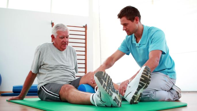 在康复中心帮助病人膝关节活动的理疗师