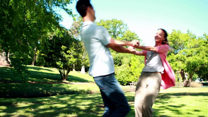 一对年轻夫妇在一个阳光灿烂的日子里在公园里玩