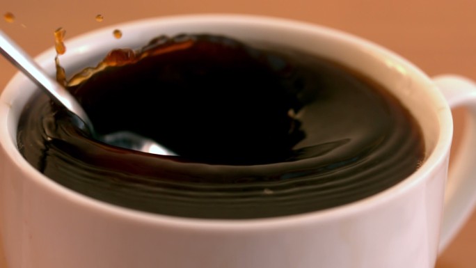 慢动作将一茶匙糖放入咖啡杯中