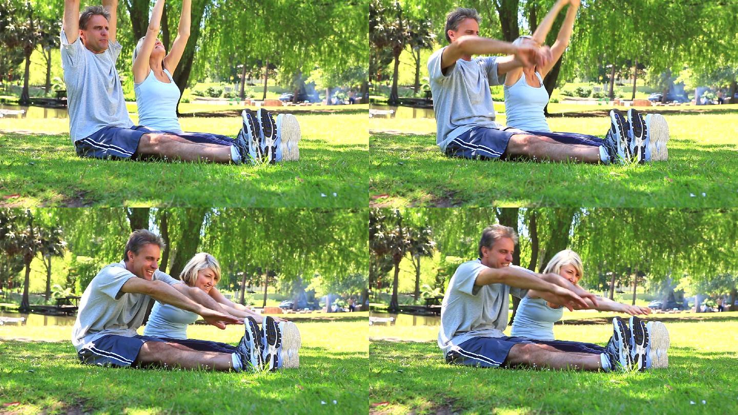 一对情侣在一个阳光明媚的日子里一起在公园里伸展身体