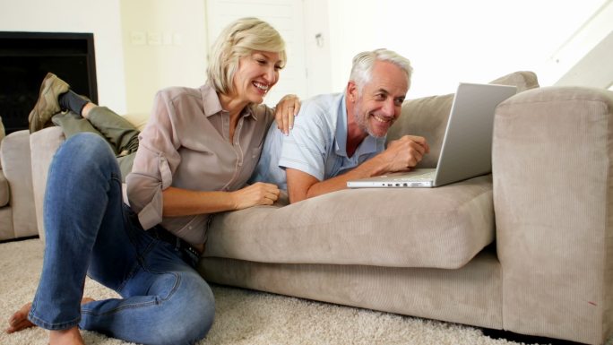 一对幸福的夫妇在客厅里一起使用笔记本电脑
