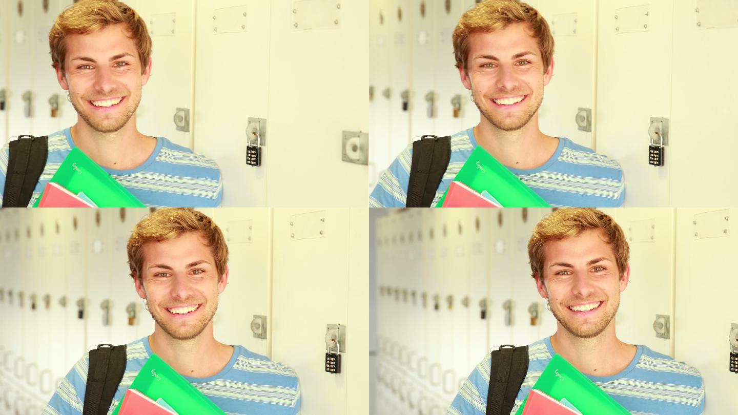 英俊的学生倚在储物柜看着摄像机在大学
