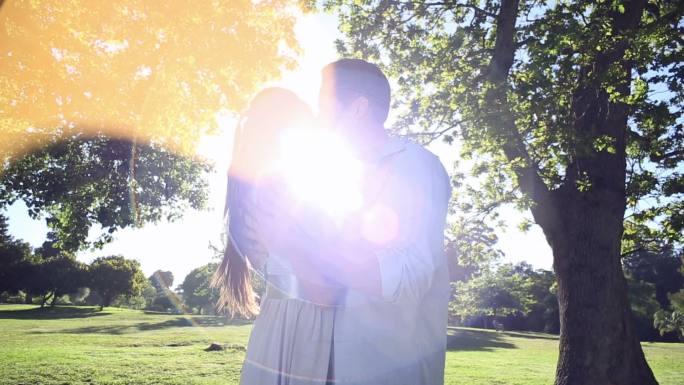 一对快乐的情侣在一个阳光灿烂的日子里在公园里跳舞