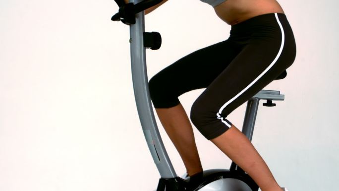 健身自行车上的健康女子慢动作