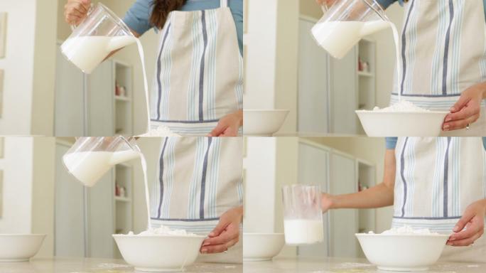 在厨房里，妇女把牛奶倒进一碗面粉里