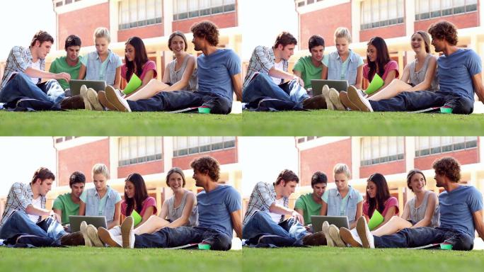 同学们坐在大学里的草地上聊天