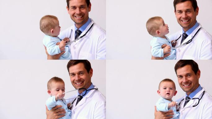 英俊的儿科医生抱着一个男婴在医院的办公室里