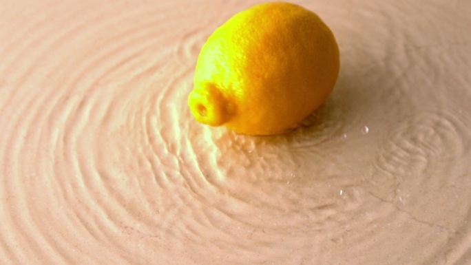 慢镜头中柠檬在潮湿的白色表面上旋转