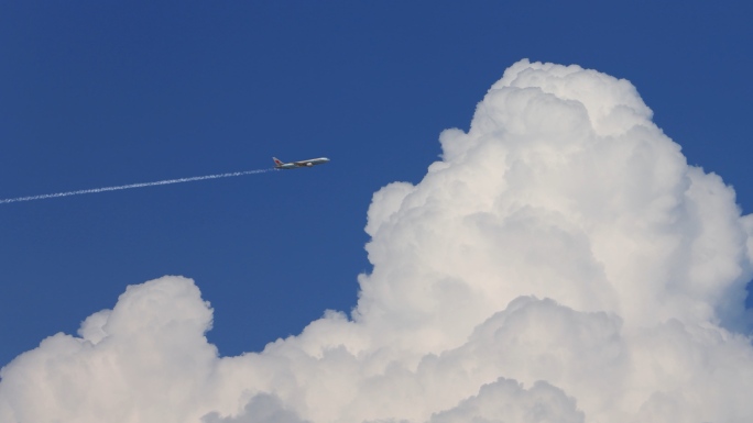 飞机在蓝天白云间飞过_4K视频素材