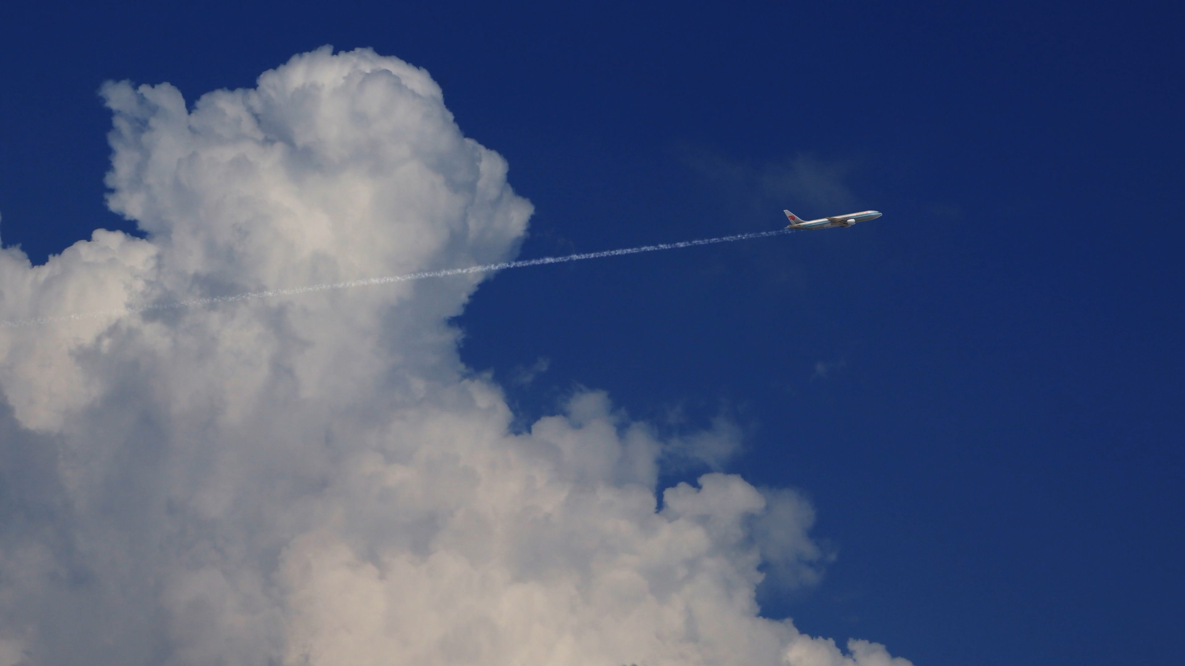 飞机在蓝天白云间飞过_4k视频素材
