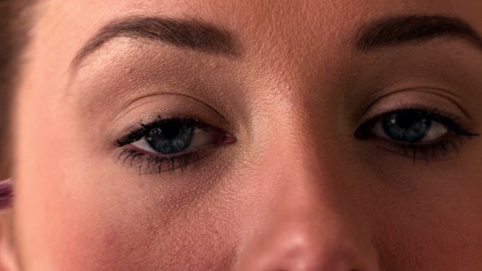 女人用眼影在眼睛上的慢动作特写