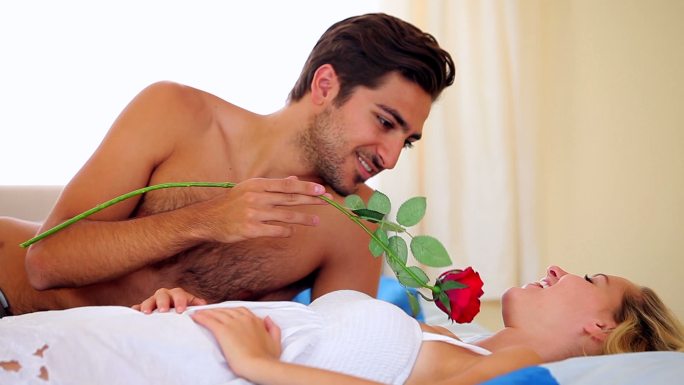 一个西方男子用红玫瑰与女朋友调情