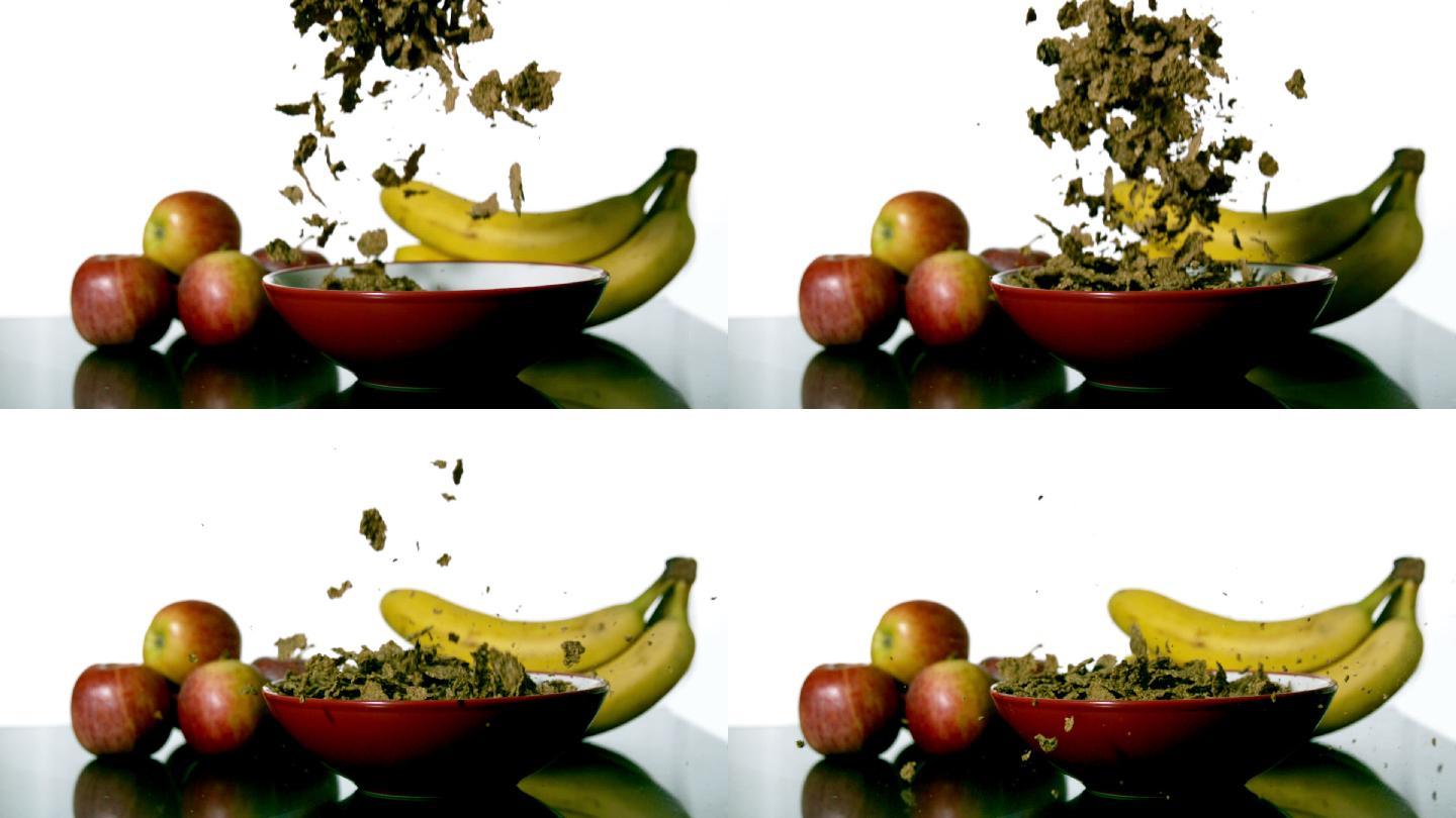 慢镜头里，麦片落在水果旁边的碗里
