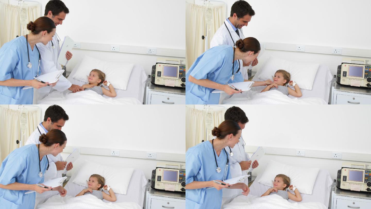 生病的小女孩躺在病床上和医院的护士和医生交谈