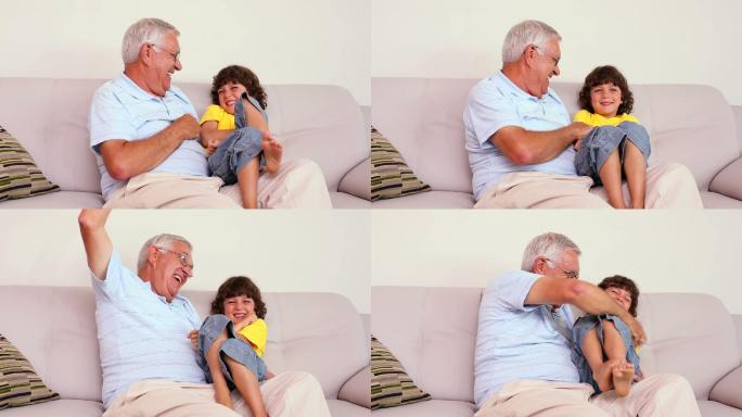 老人和他的孙子坐在客厅的沙发上